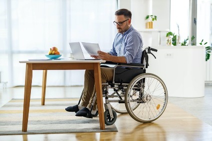 Man on wheelchair reading long term disability papers