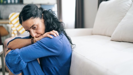 Sad woman sitting suffering from an invisible illness