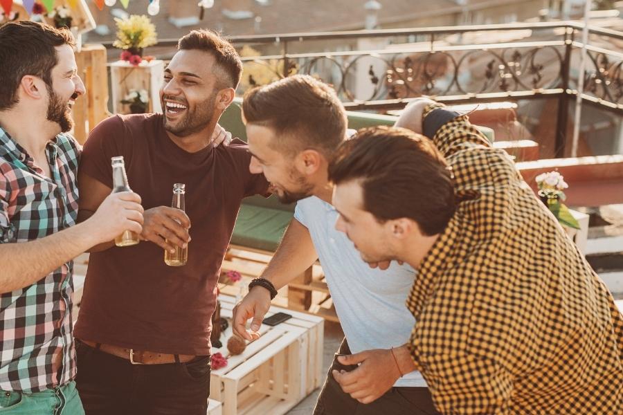 Guys out at a bar having fun, but at the end of the night they'll call an Uber.