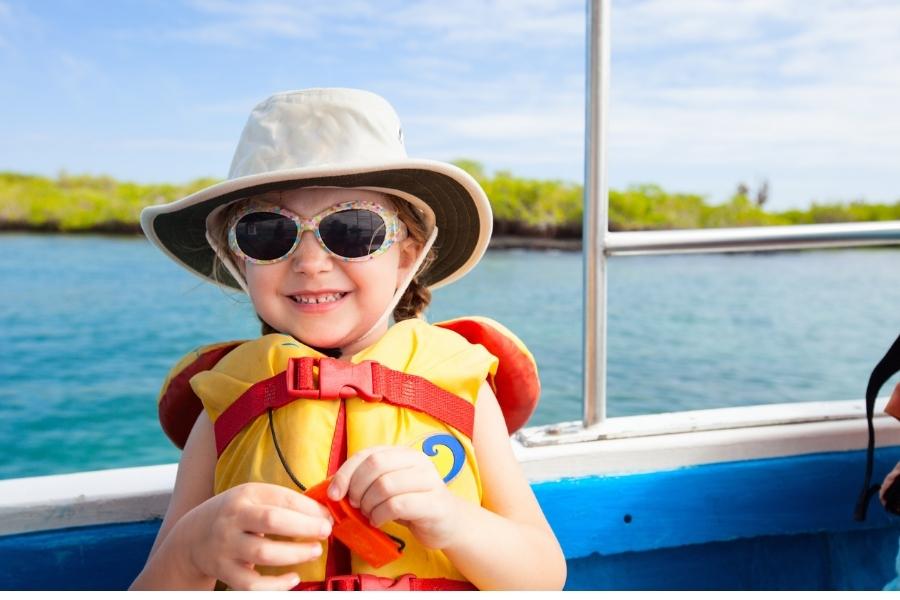 Child in a boat wearing a life jacket for safety.