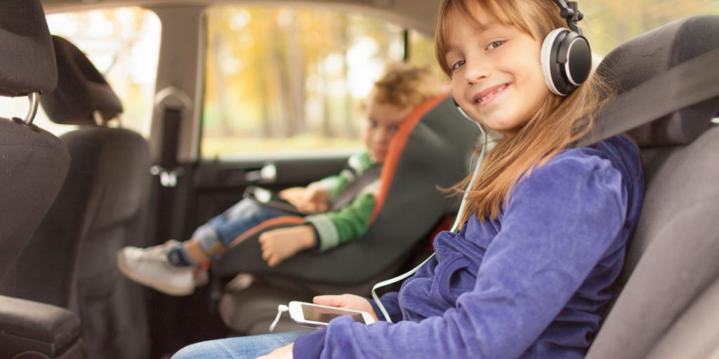 Young 8 year old girl is ready to use a seatbelt when in the car.