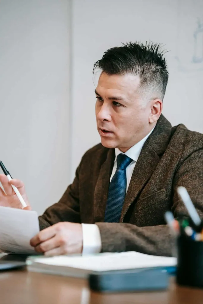 Professional businessman holding documents and explaining points during an office meeting.